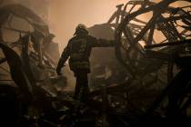 A Ukrainian firefighter walks inside a large food products storage facility which was destroyed ...