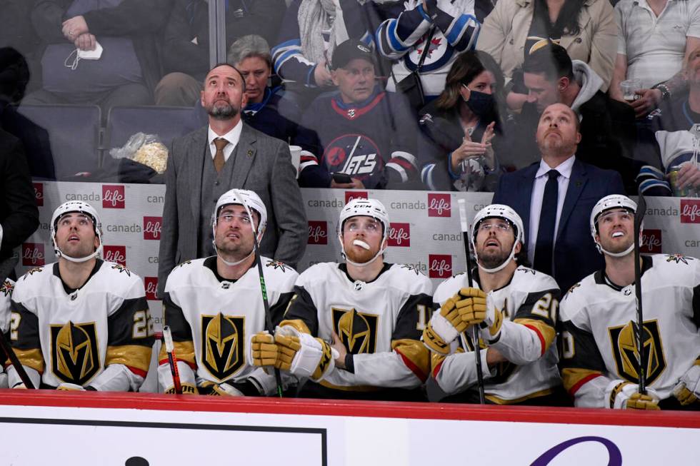 Vegas Golden Knights coach Pete DeBoer, left, and players look up to view a replay of a Winnipe ...