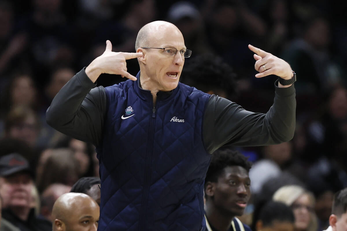 Akron head coach John Groce signals during the first half of an NCAA college basketball game ag ...