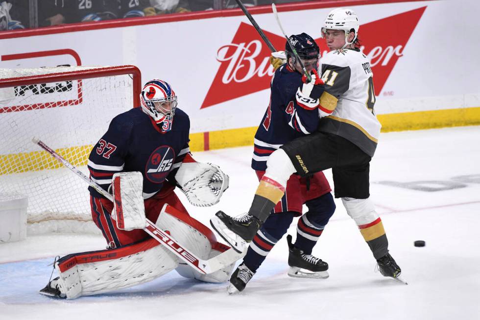 Winnipeg Jets' Neal Poink (4) checks Vegas Golden Knights' Nolan Patrick (41) in front of goalt ...