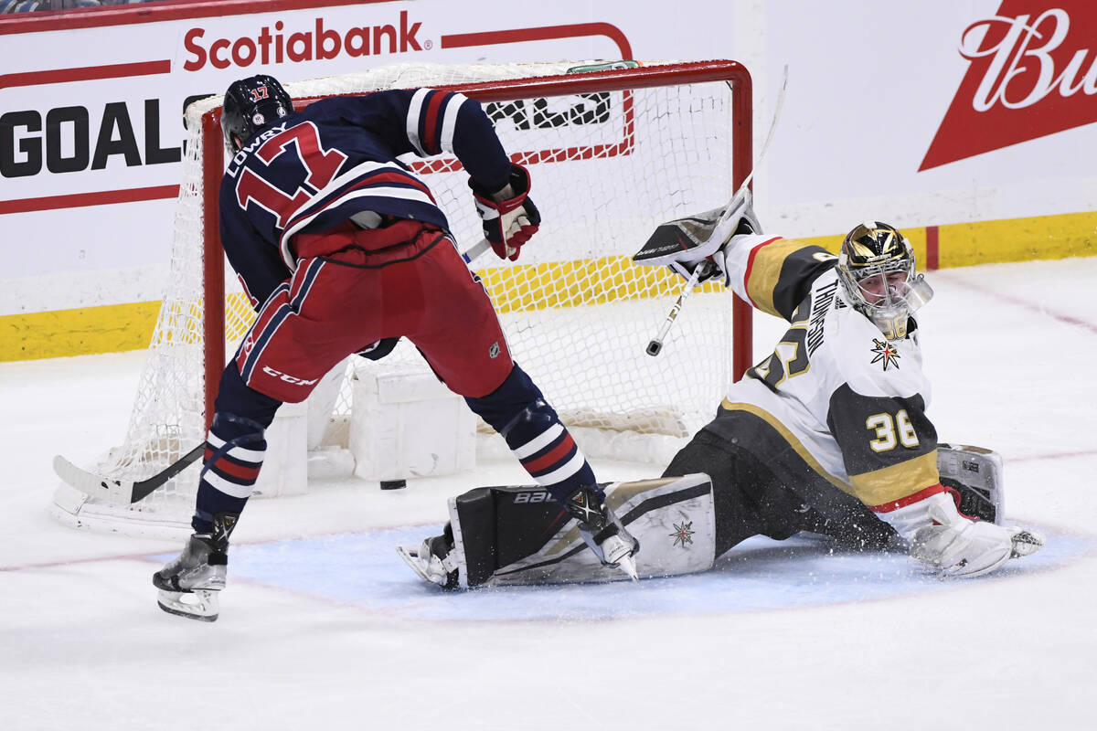 Winnipeg Jets' Adam Lowry (17) scores on Vegas Golden Knights goaltender Logan Thompson (36) du ...