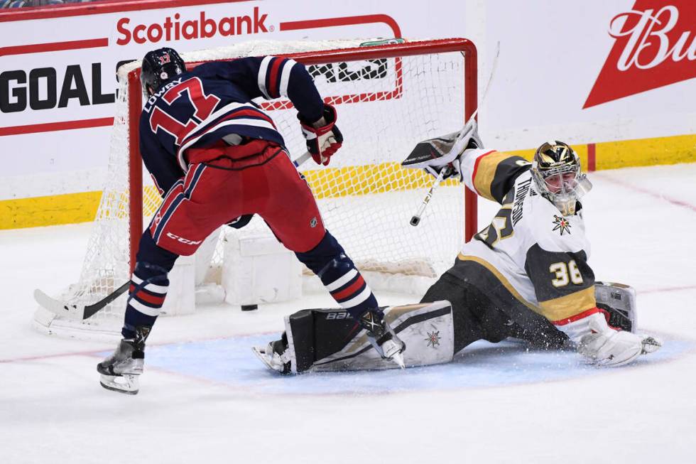 Winnipeg Jets' Adam Lowry (17) scores on Vegas Golden Knights goaltender Logan Thompson (36) du ...