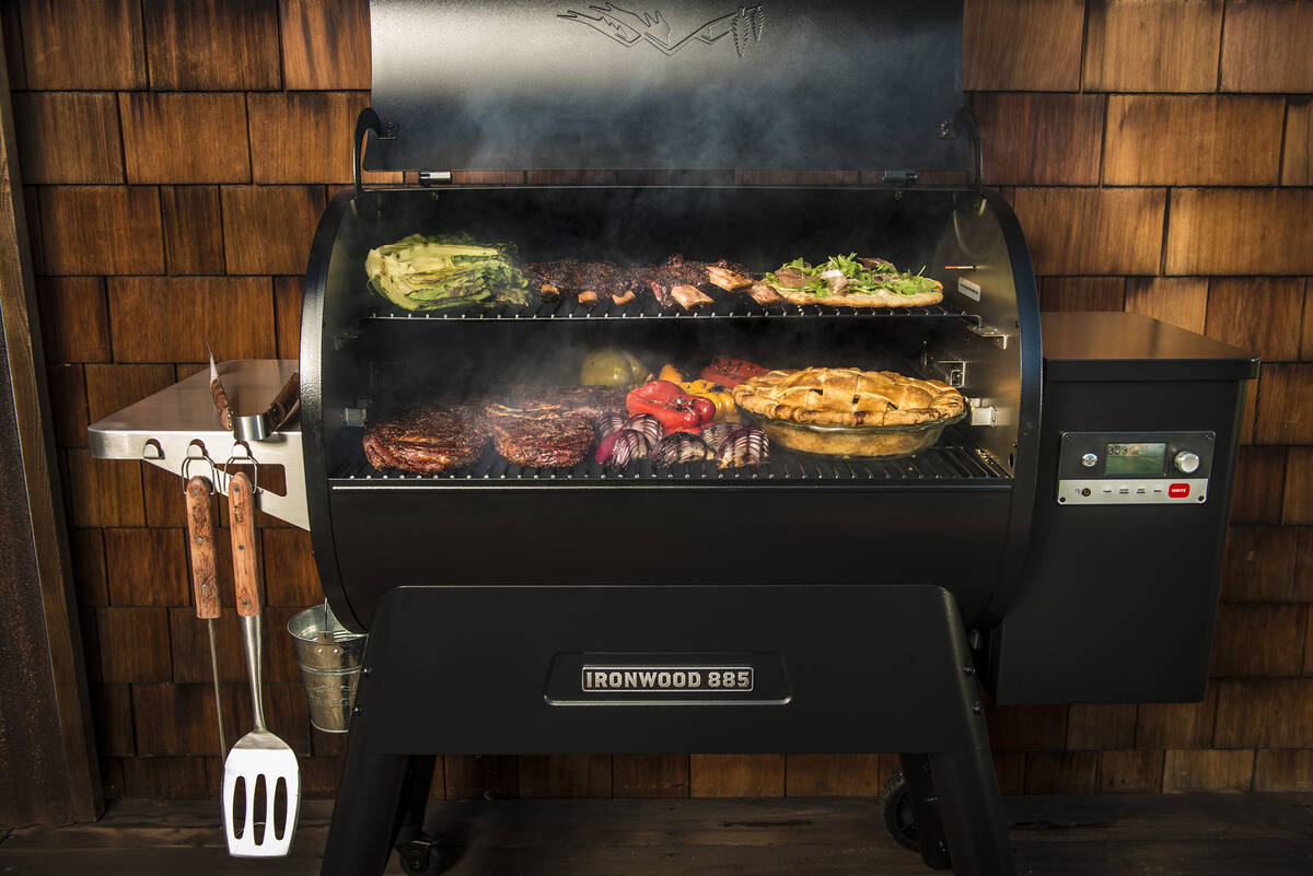 A pellet grill, such as this Traeger Ironwood model, looks like a gas grill, with a metal hoppe ...