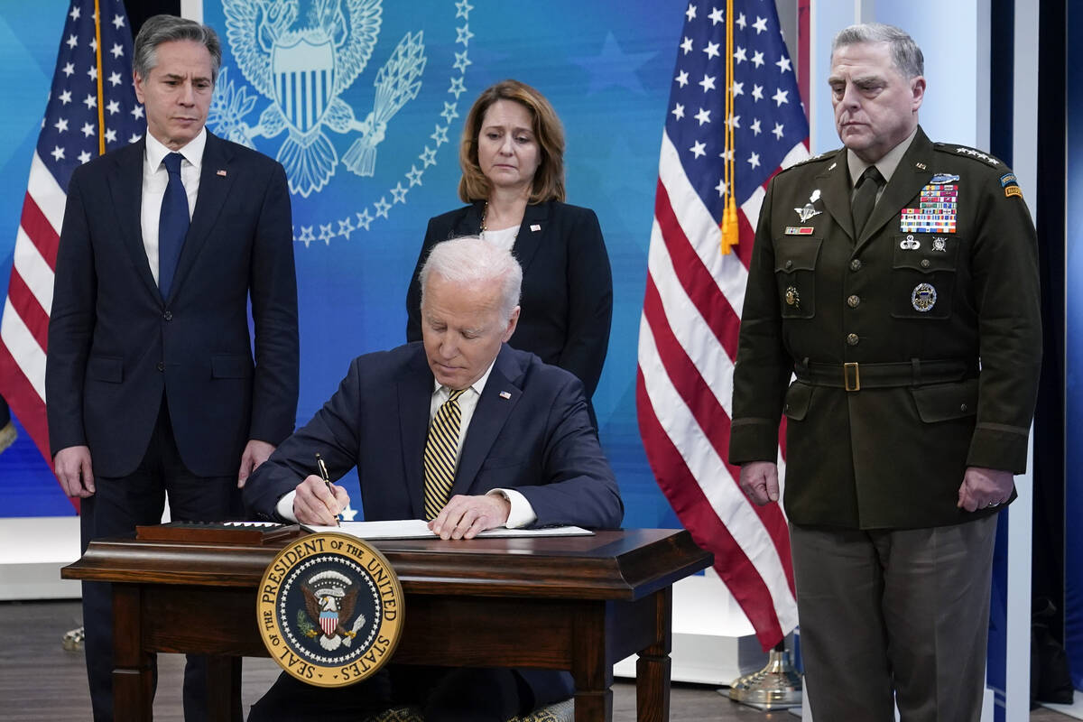 President Joe Biden signs a delegation of authority in the South Court Auditorium on the White ...