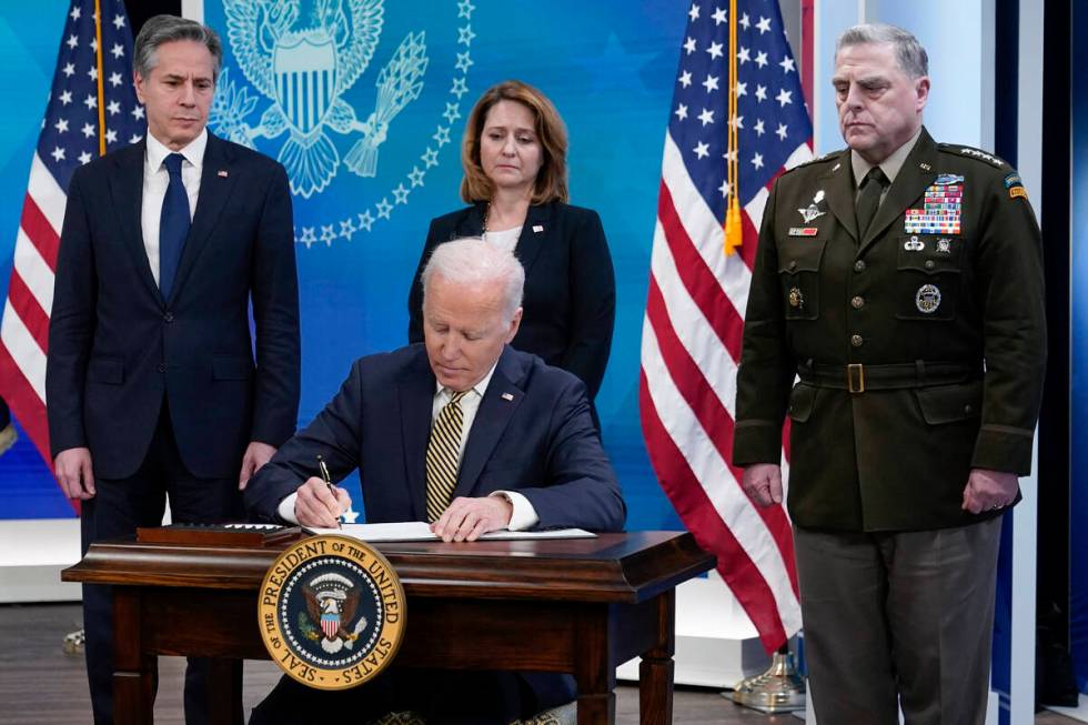 President Joe Biden signs a delegation of authority in the South Court Auditorium on the White ...