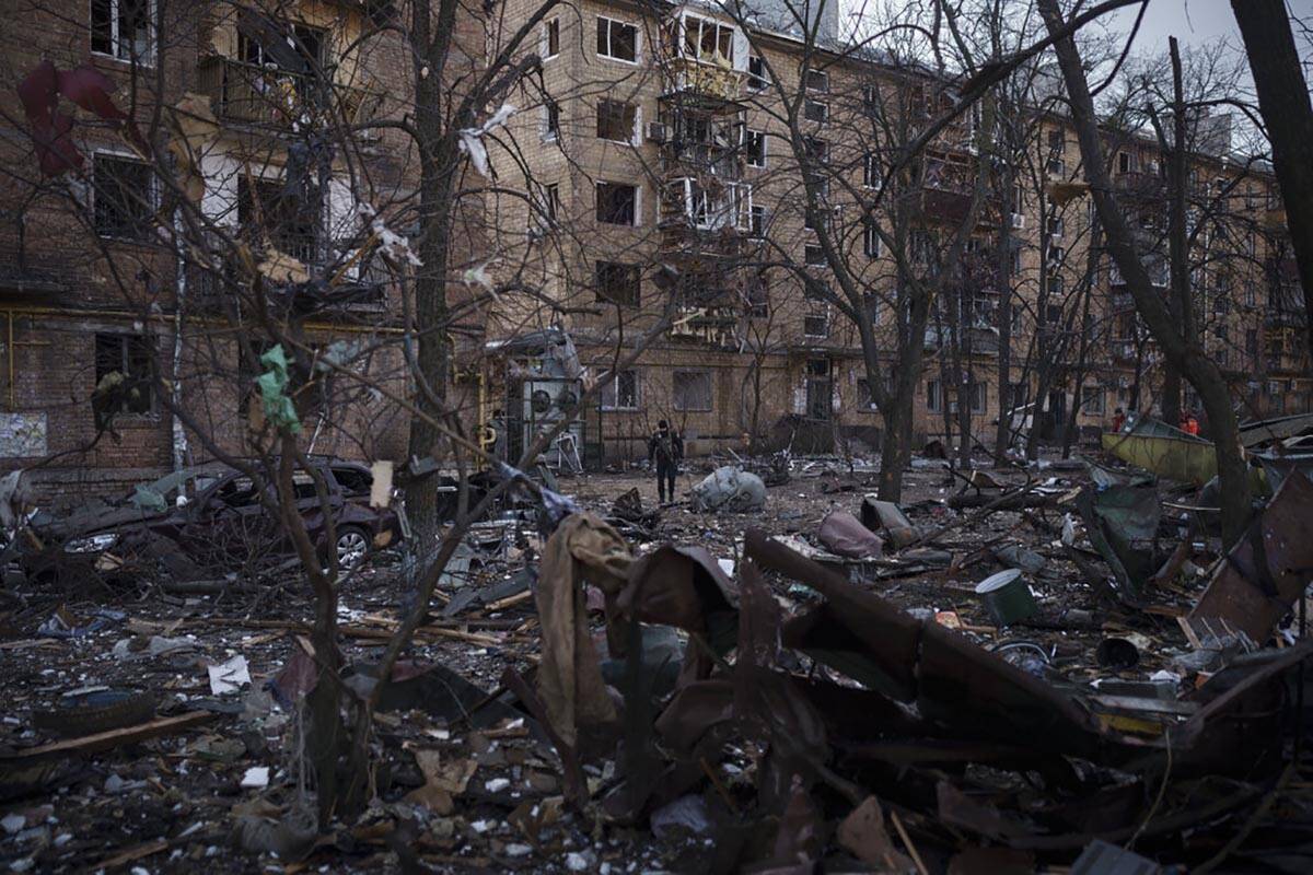 A police officer walks at the site of a bombing that damaged residential buildings in Kyiv, Ukr ...