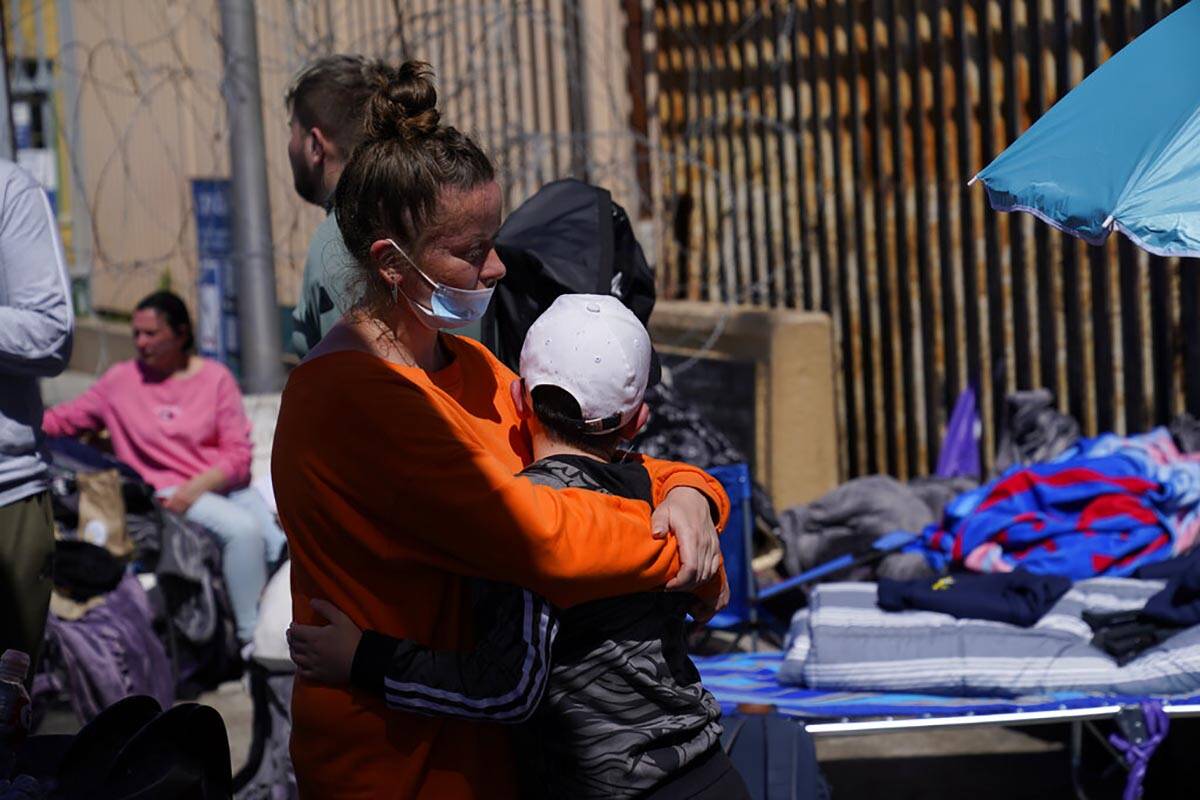 A Russian woman hugs her son as they wait near the San Ysidro Port of Entry leading into the Un ...