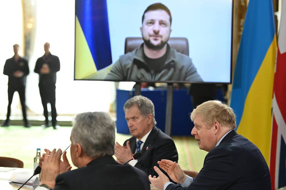 Britain's Prime Minister Boris Johnson and attendees applaud after Ukraine's President Volodymy ...