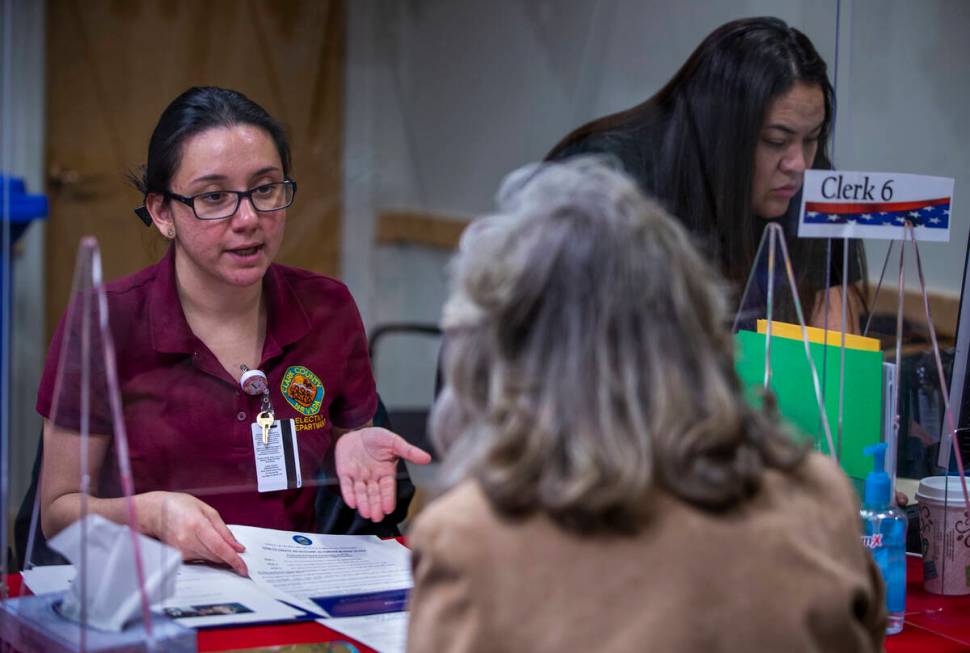 Election Operations Specialist Lupita Ramirez, left, confirms paperwork with Rep. Dina Titus, D ...
