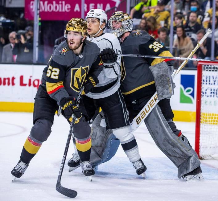 Golden Knights defenseman Dylan Coghlan (52) and Los Angeles Kings center Trevor Moore (12) bat ...