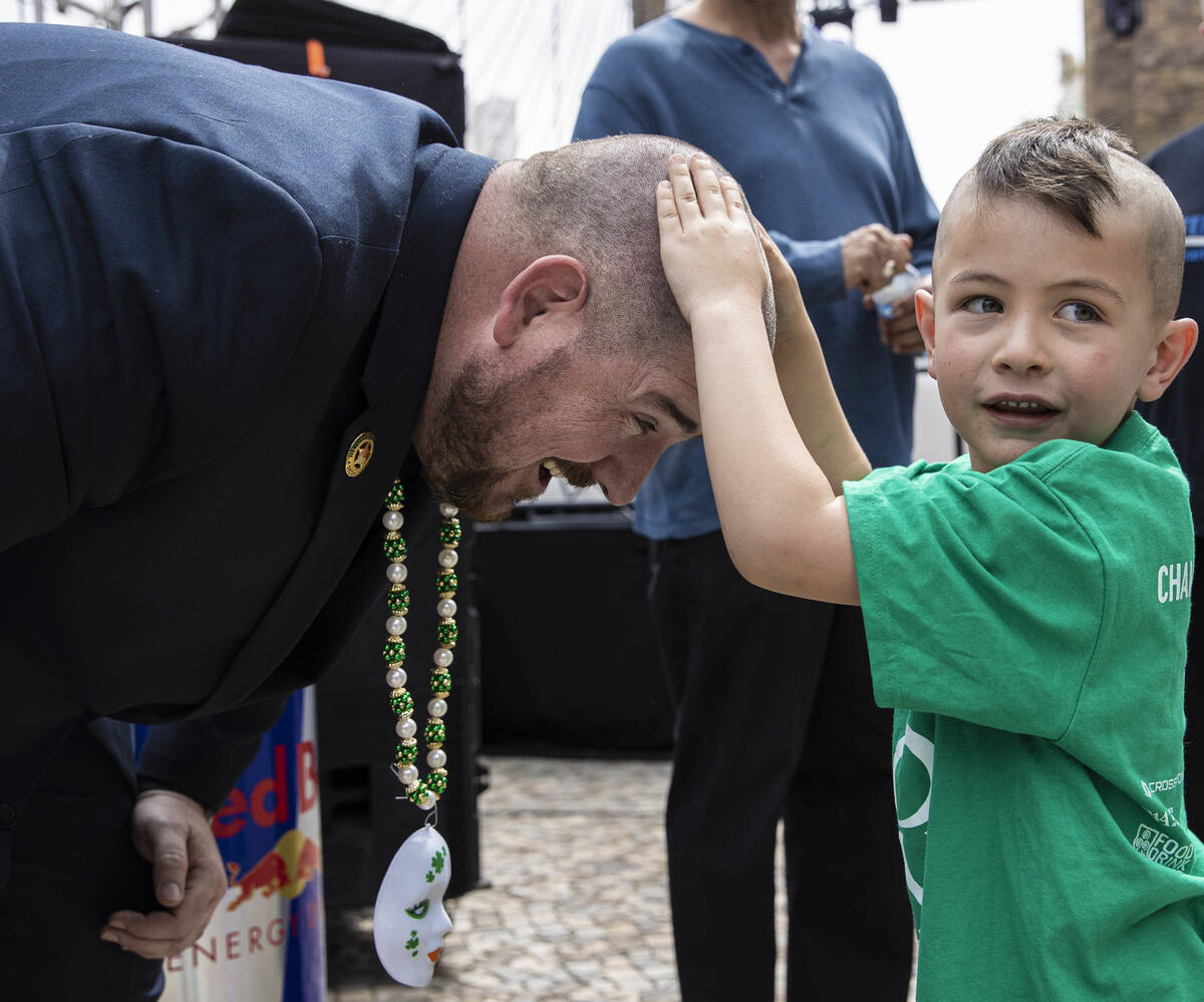 Cayden Creazzo, right, 4, feels father Anthony’s newly shaved head during the annual St. ...
