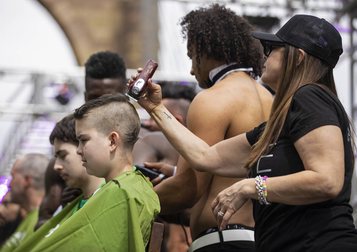 Toby Brooks, left, gets his head shaved during the annual St. Baldrick's fundraising event bene ...