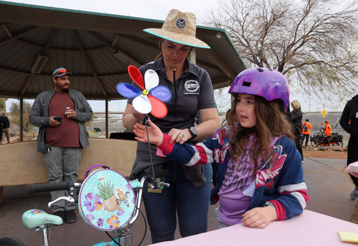 Pacey Crose, 7, and her mom, Kalie Daly Crose, decorate her bike during the opening o ...