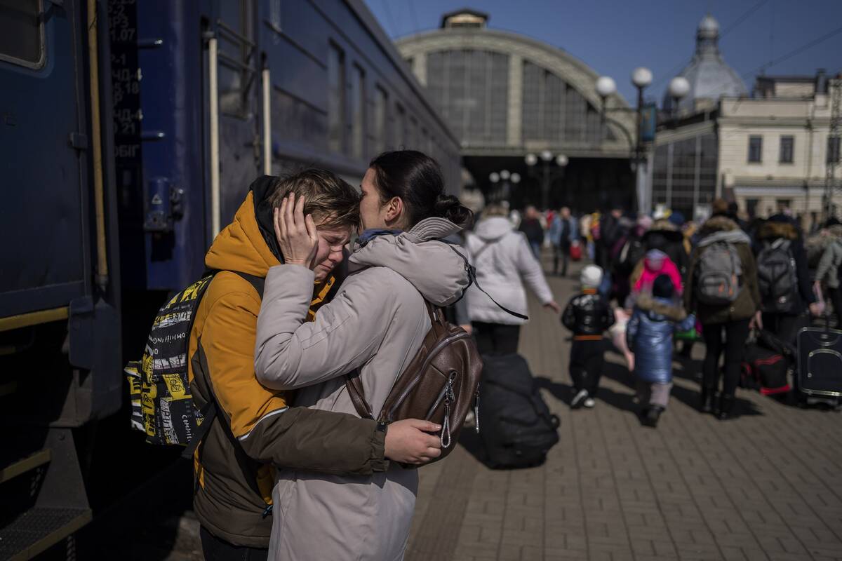 A mother embraces her son who escaped the besieged city of Mariupol and arrived at the train st ...