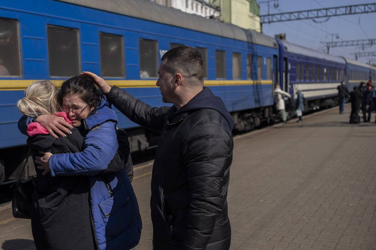 Olga Nikitina, center, who escaped the besieged city of Mariupol embraces her sister after arri ...