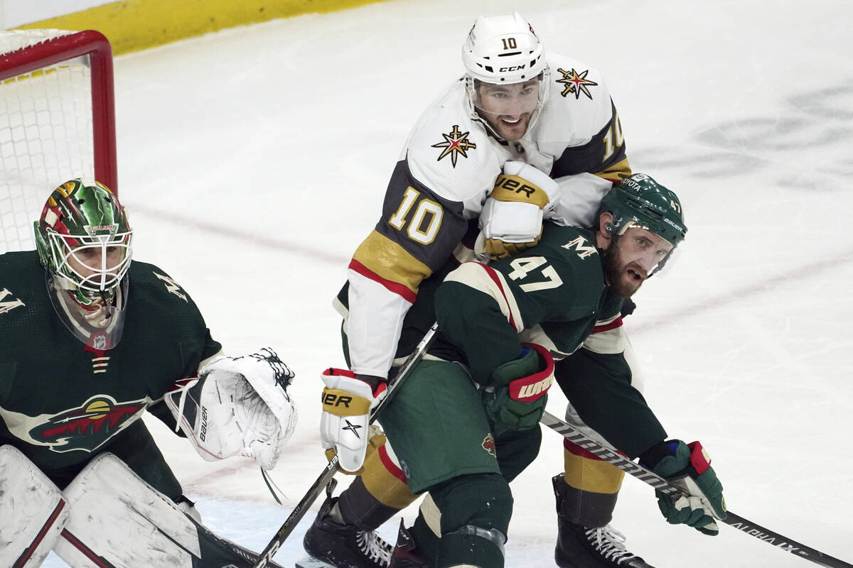 Minnesota Wild's Alex Goligoski (47) keeps Vegas Golden Knights' Nicolas Roy (10) at bay as he ...