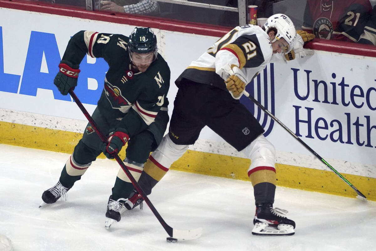 Minnesota Wild's Tyson Jost, left, moves the puck as Vegas Golden Knights' Brett Howden looks f ...