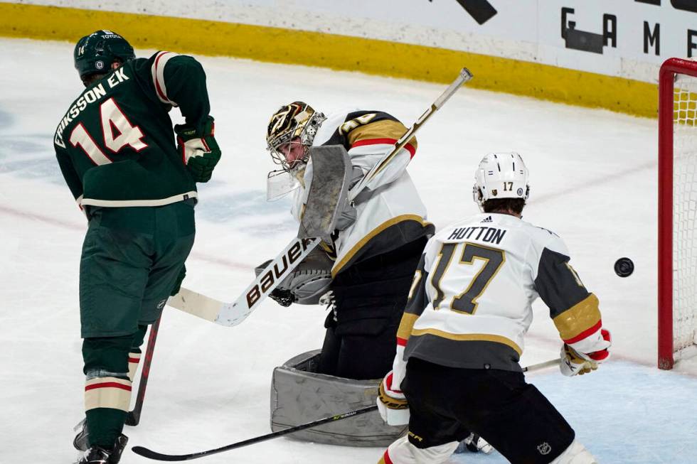 Vegas Golden Knights goalie Logan Thompson, center, deflects a shot by Minnesota Wild's Joel Er ...