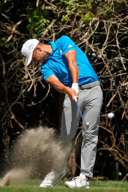 Xander Schauffele takes a divot as he tees off on the third hole during the final round of the ...