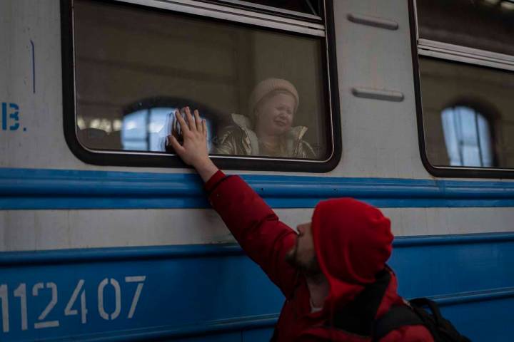 Displaced Ukrainians on a Poland-bound train bid farewell in Lviv, western Ukraine, Tuesday, Ma ...