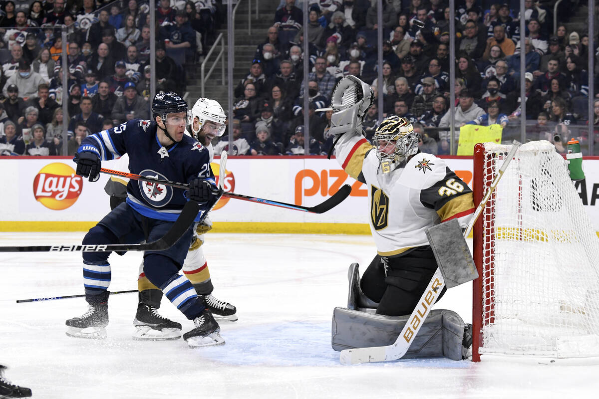 Winnipeg Jets' Paul Stastny (25) watches the puck as it goes over Vegas Golden Knights goaltend ...