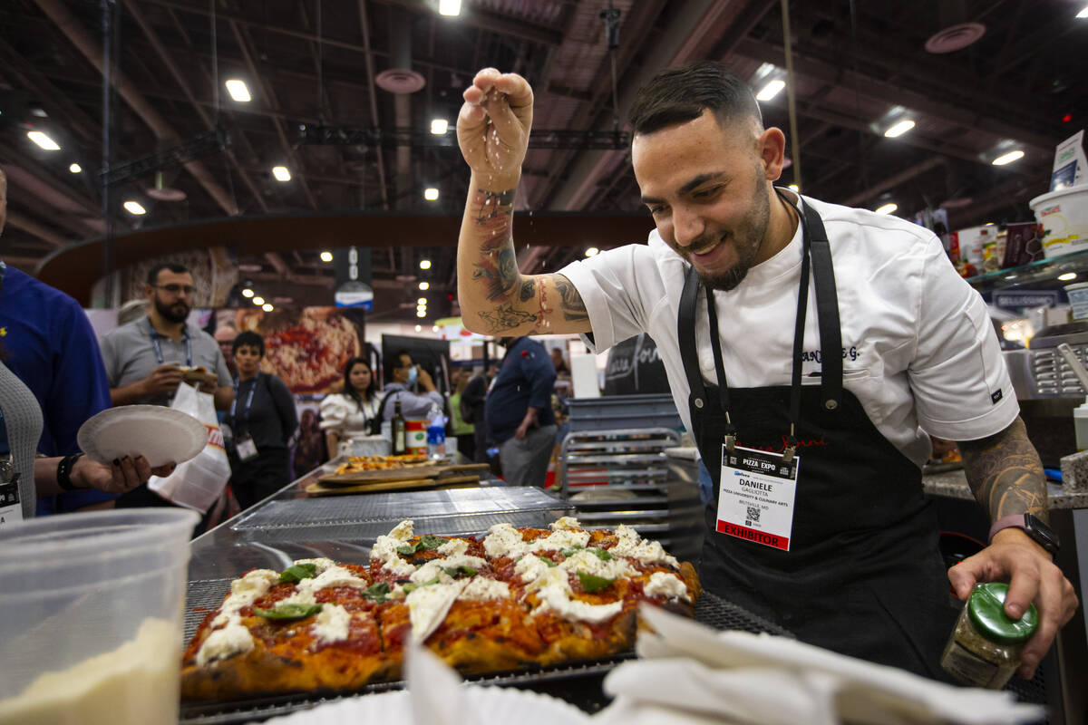Chef Daniele Gagliotta prepares pizza at the Marra Forni Brick Oven Cooking Solutions booth dur ...