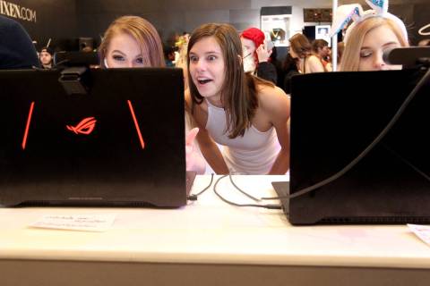 Skye Watson, from left, University Liz and Scarlet LoveU greet fans on webcams during AVN Adult ...