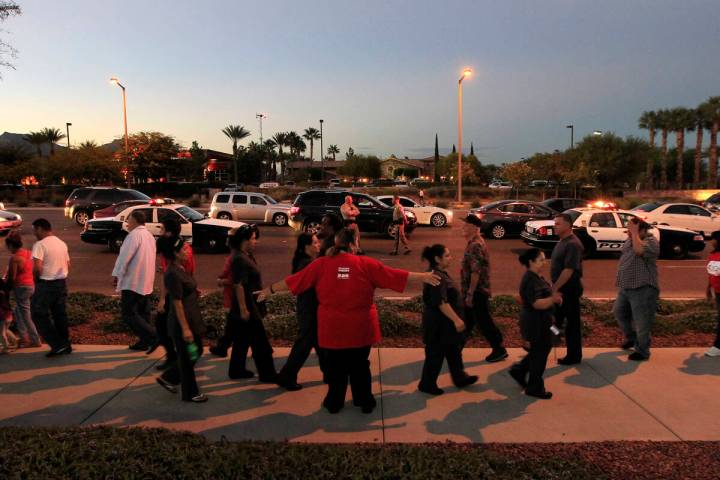 Union members and supporters march along the sidewalk during a Culinary Local 226 protest outsi ...