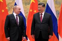 FILE - Chinese President Xi Jinping, right, and Russian President Vladimir Putin talk to each o ...