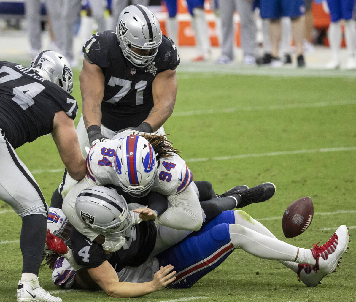 Las Vegas Raiders quarterback Derek Carr (4) looses control of the ball while being tackled by ...