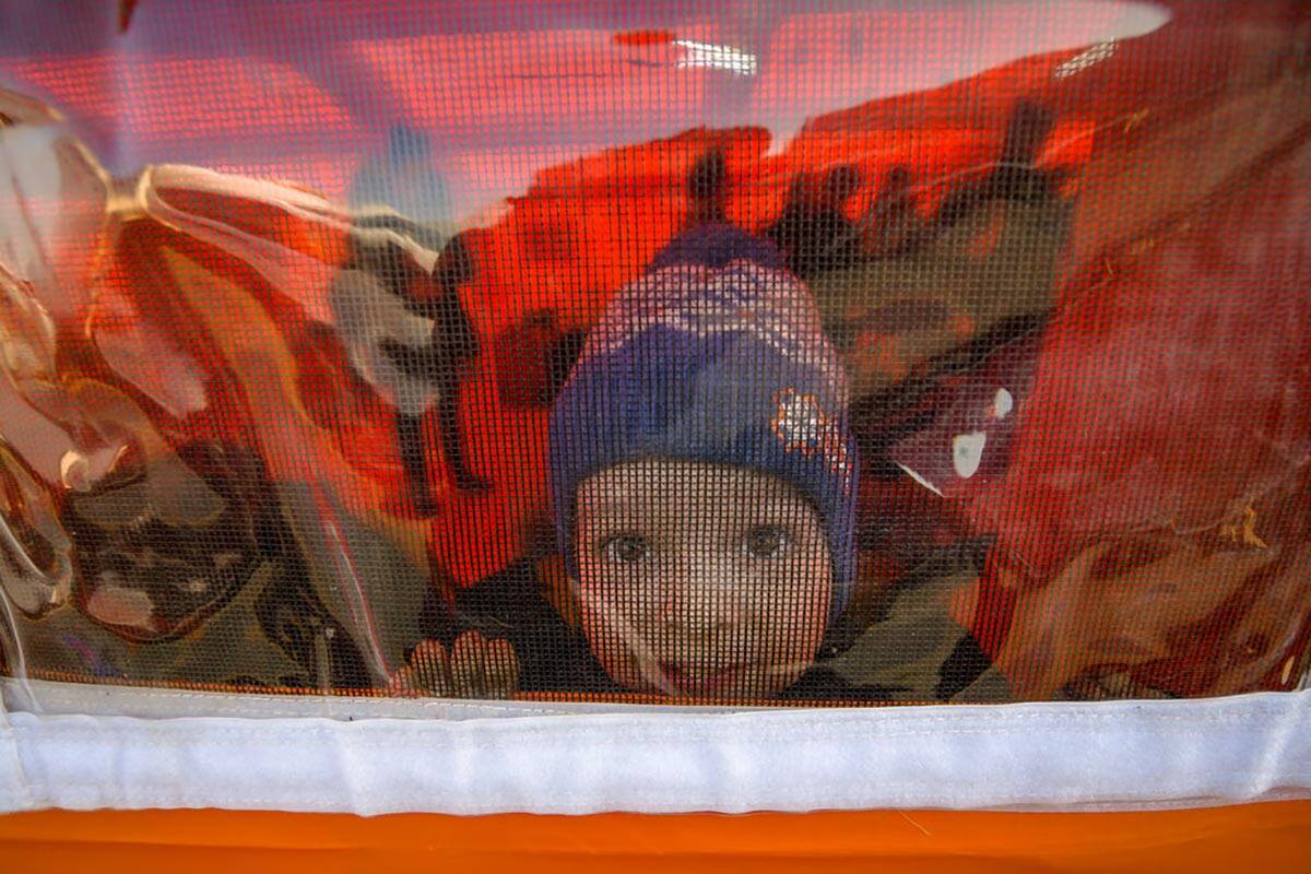 A refugee fleeing the war from neighboring Ukraine with his family looks out of a tent after cr ...