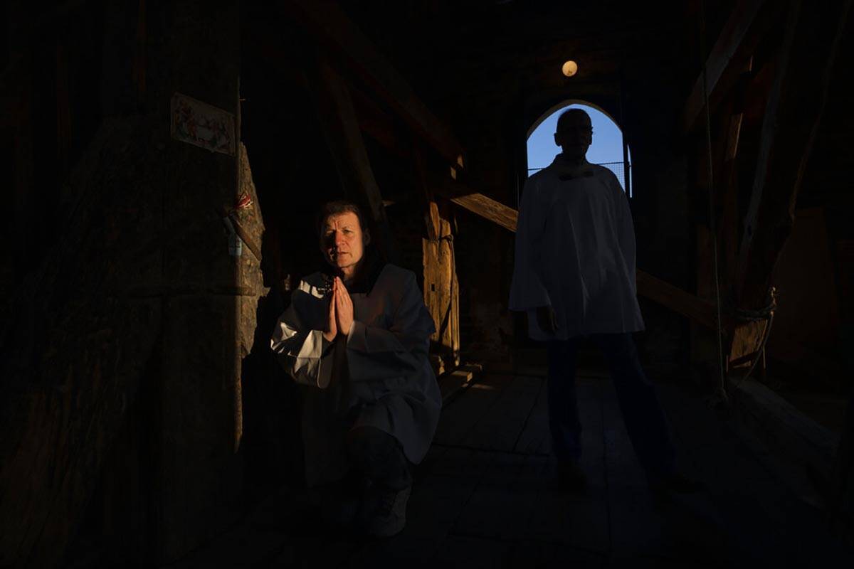 Retired policeman, Volodymyr Ilnytskyi, 55, prays before ringing the bell of the Latin Cathedra ...