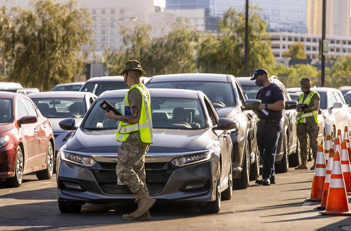 Cars make it to the front of the line at the drive-thru COVID-19 tests and vaccinations offered ...