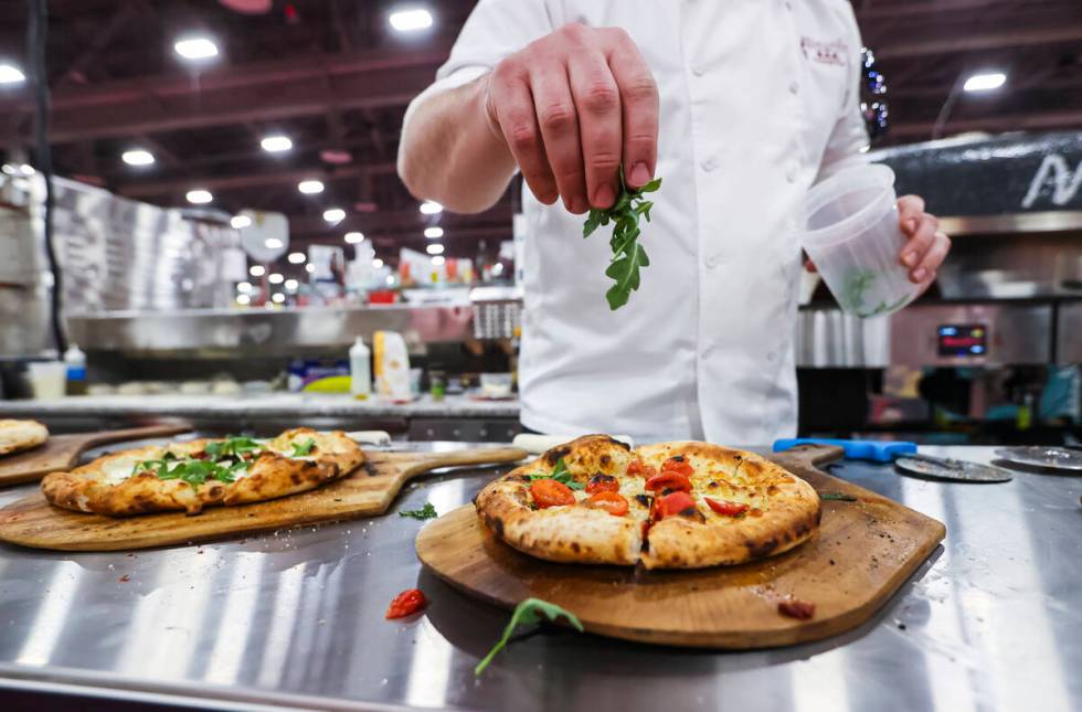 Pizza is prepared at the Marra Forni Brick Oven Cooking Solutions booth during the Internationa ...
