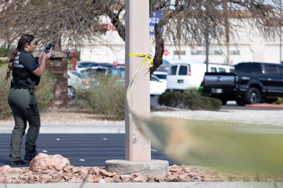 A crime scene investigator photographs the scene where a motorcyclist died in a crash at the in ...