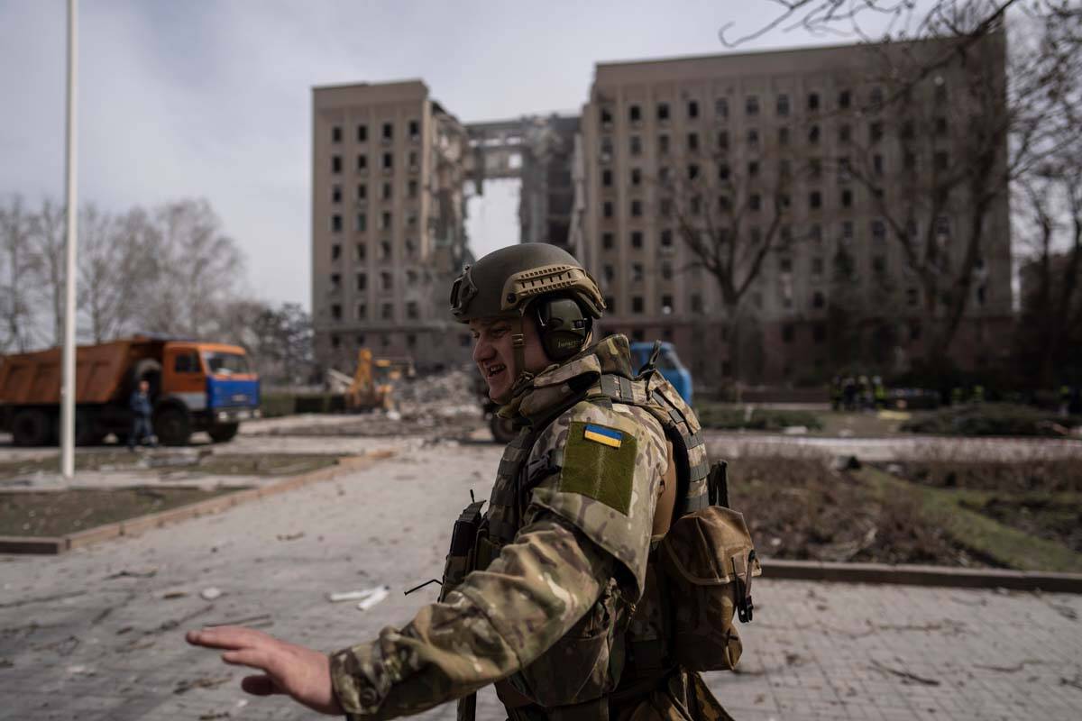 A Ukrainian soldier secures the area next to the regional government headquarters of Mykolaiv, ...