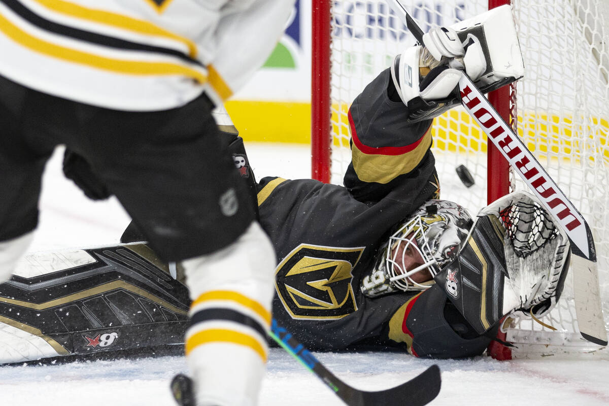 Golden Knights goaltender Robin Lehner (90) dives but misses the save on a shot by Bruins cente ...