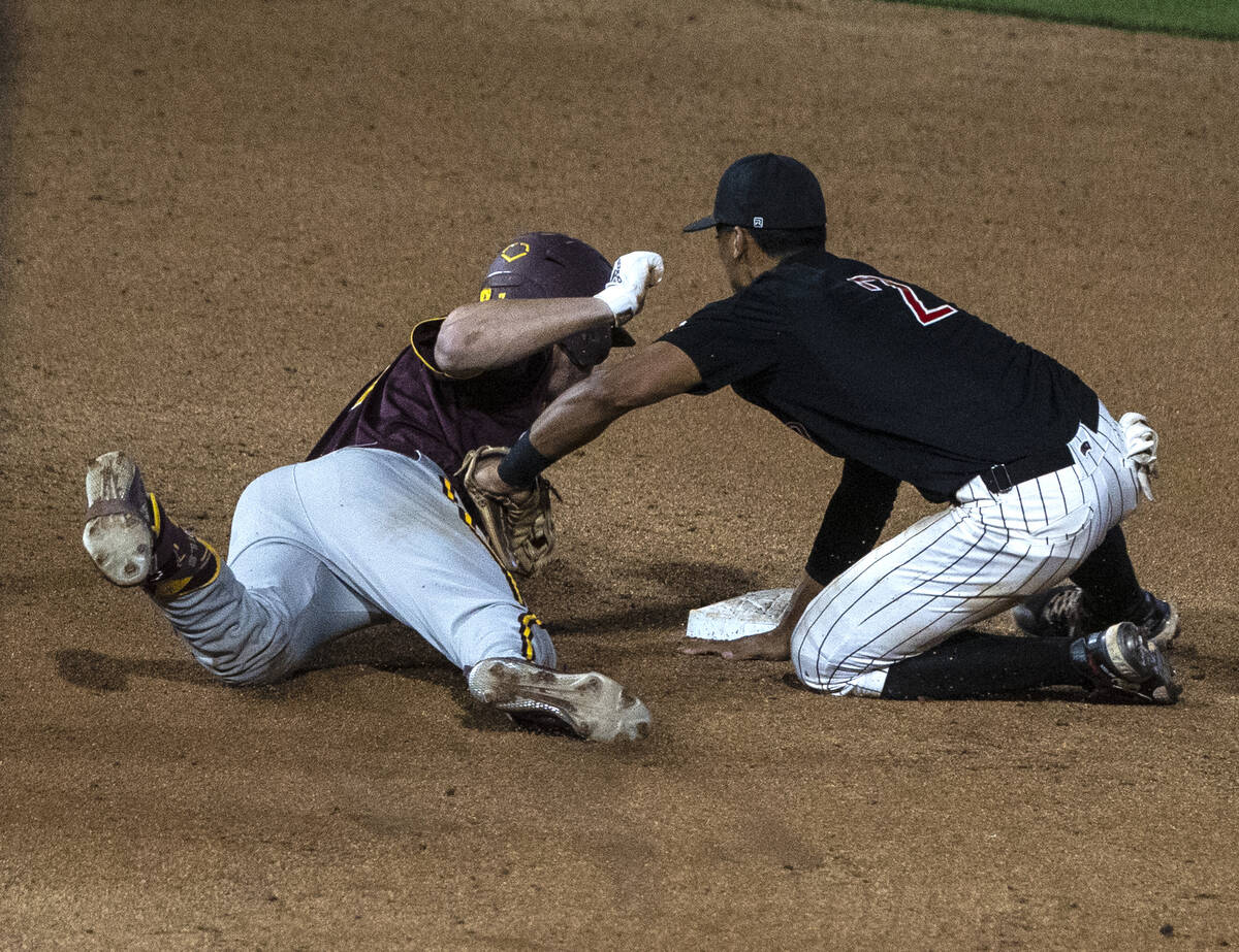 Arizona St. outfielder Conor Davis (7) is tagged out by UNLV infielder Edarian Williams (2) at ...