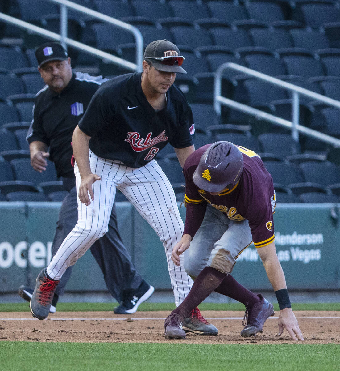 Arizona St. outfielder Joe Lampe (5) is tagged out by UNLV infielder Diego Alarcon (6) at third ...