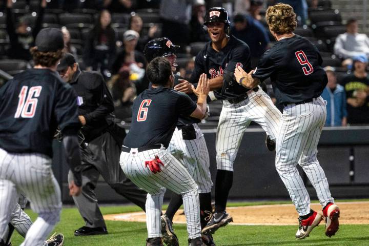 UNLV infielder Edarian Williams (2) celebrates with his teammates after scoring the winning run ...