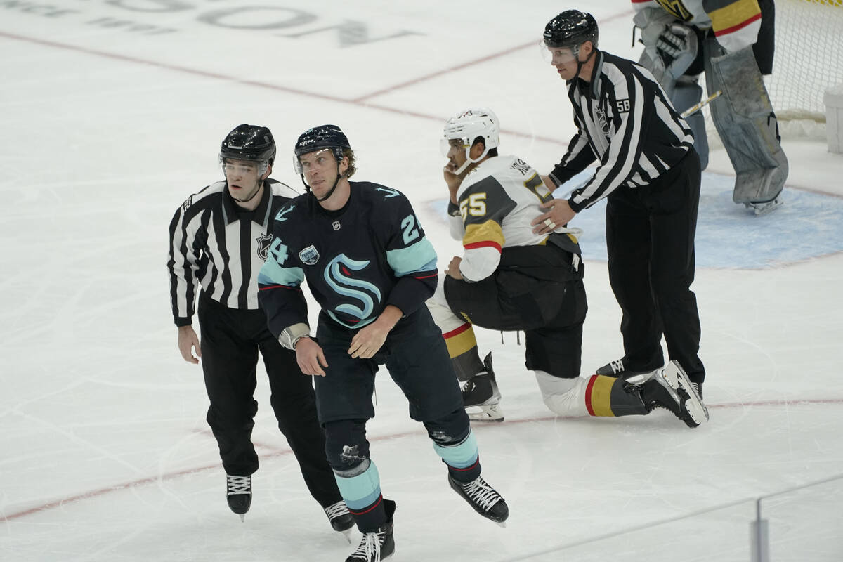 Seattle Kraken defenseman Jamie Oleksiak, second from left, heads to the penalty box after figh ...