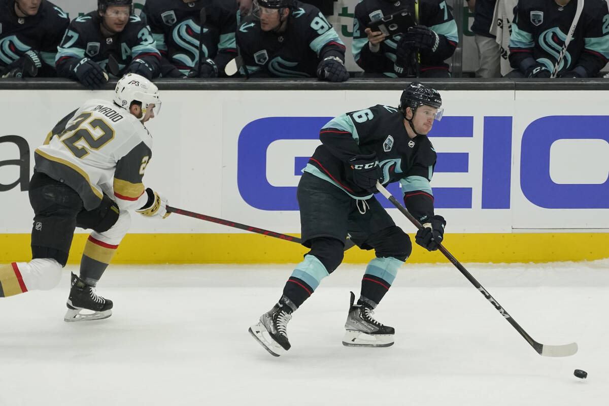 Seattle Kraken left wing Jared McCann, right, moves the puck ahead of Vegas Golden Knights cent ...