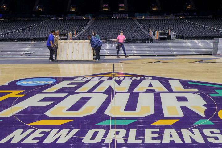 Workers install the court for the 2022 men's Final Four NCAA college basketball tournament at t ...
