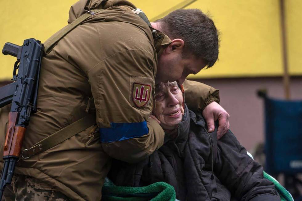 A soldier comforts Larysa Kolesnyk, 82, after she was evacuated from Irpin, on the outskirts of ...