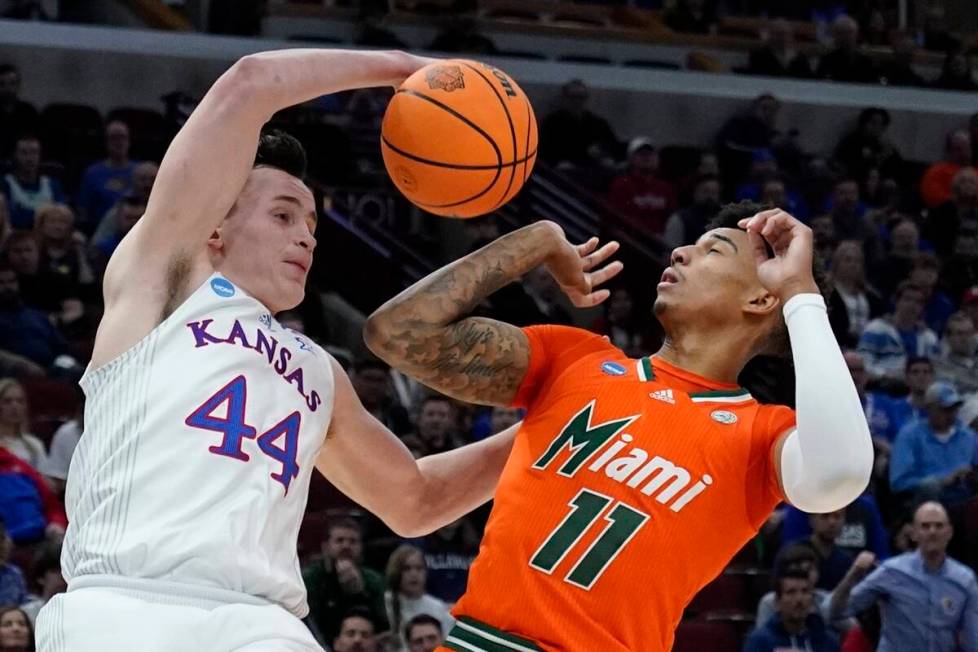 Kansas' Mitch Lightfoot and Miami's Jordan Miller go for a rebound during the second half of a ...