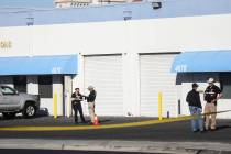 Police investigate the scene where a warehouse employee fatally shot a man who was stealing his ...