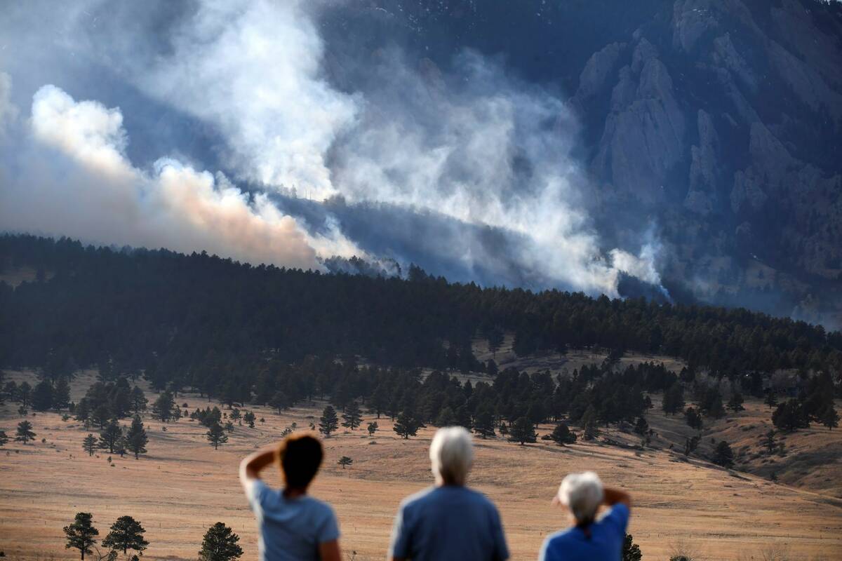 From left, Laura Tyson, Tod Smith and Rebecca Caldwell, residents of Eldorado Springs, watch as ...