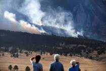 From left, Laura Tyson, Tod Smith and Rebecca Caldwell, residents of Eldorado Springs, watch as ...