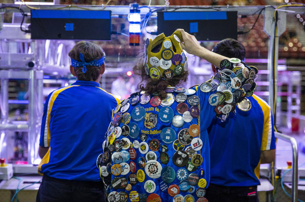 A competitor wears numerous team buttons during the FIRST Robotics Competition at the Thomas &a ...