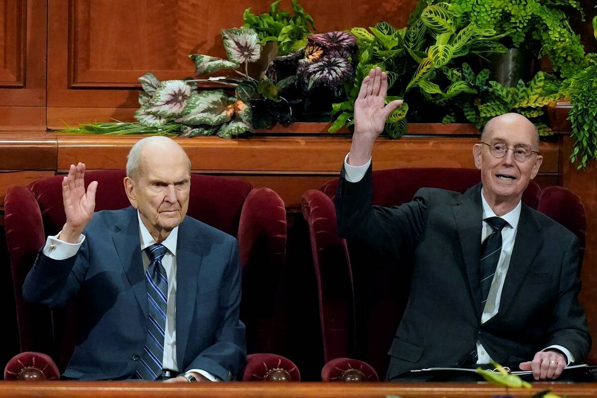 President Russell M. Nelson, left, and his counselor Henry B. Eyring, right, raise their hands ...